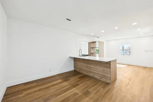 a view of a kitchen with wooden floor and a sink