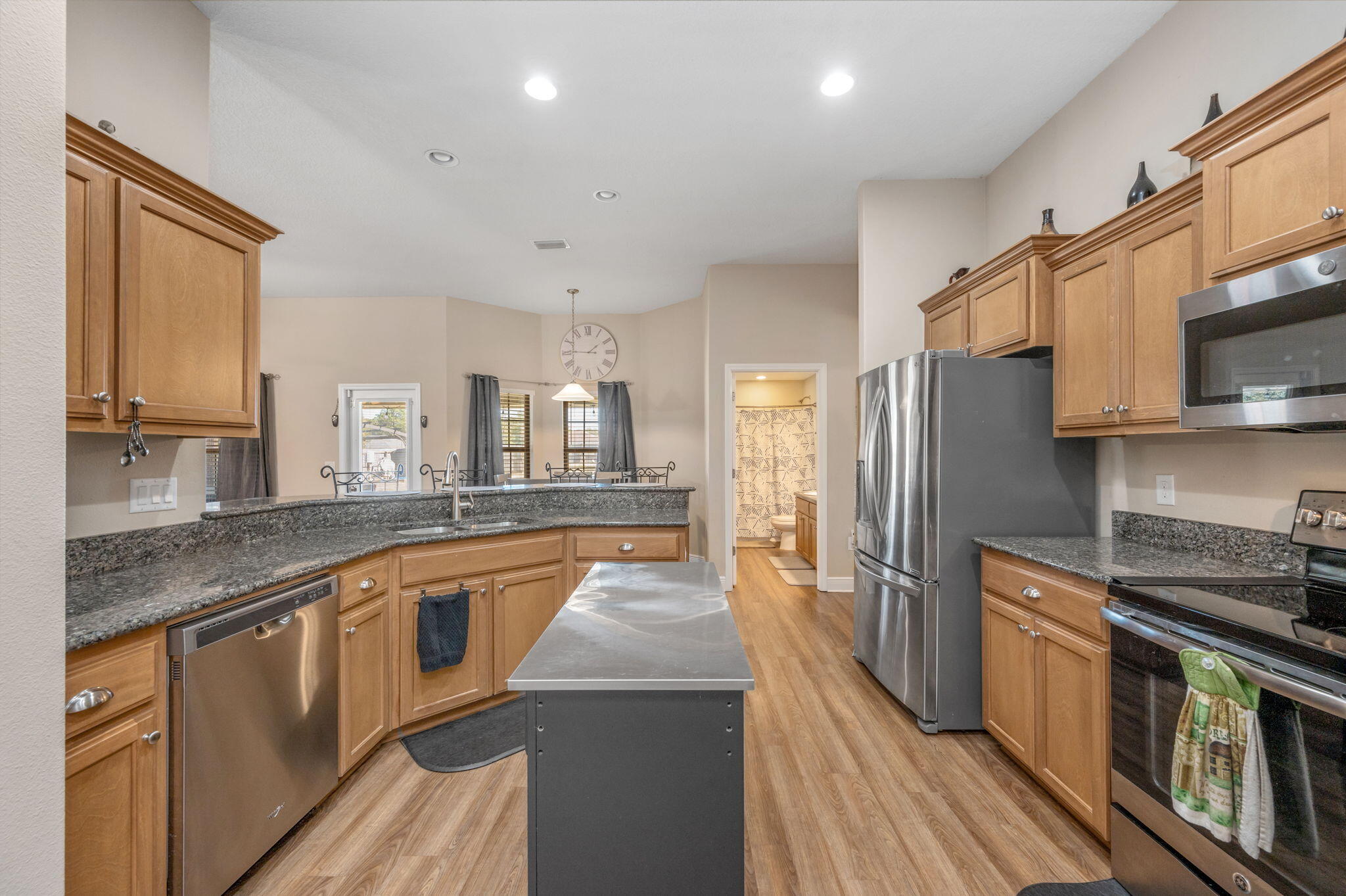 2342 Genevieve Way Crestview, FL 32536 - Photo 12 of 41 a large kitchen with stainless steel appliances granite countertop a stove a sink dishwasher and a refrigerator with wooden floor
