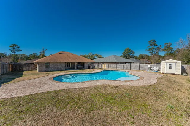 a view of a house with swimming pool and yard