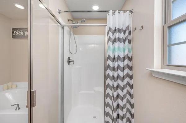 a white bath tub sitting next to a white wall