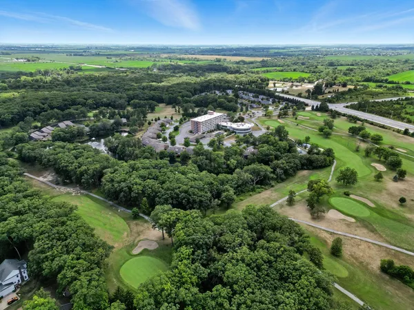 an aerial view of residential houses with outdoor space and trees