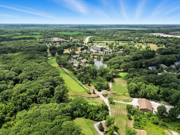an aerial view of residential houses with outdoor space and trees