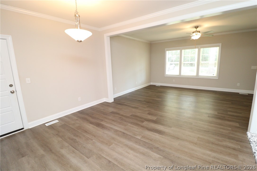 8424 Rhodes Road Apex, NC 27539 - Photo 8 of 31 an empty room with wooden floor and windows