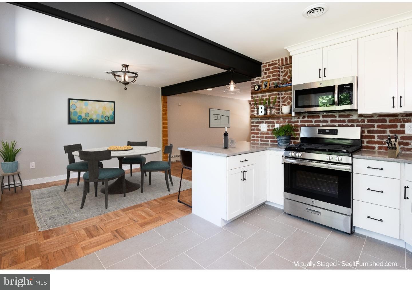 150 South Cedar Hollow Road Paoli, PA 19301 - Photo 6 of 23 a kitchen with stainless steel appliances kitchen island granite countertop a stove top oven a sink a dining table and chairs