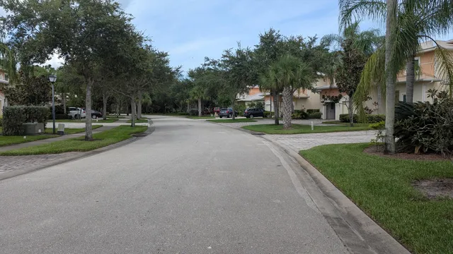 a view of a house with a big yard and palm trees