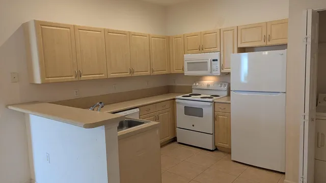 a kitchen with white cabinets and white appliances