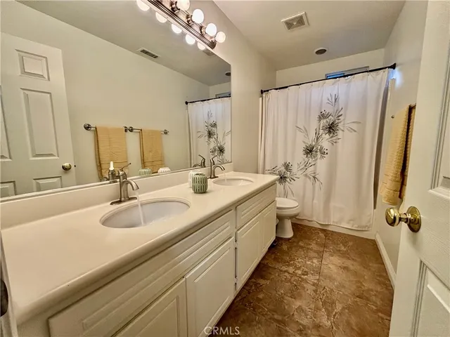 a spacious bathroom with a double vanity sink mirror and shower