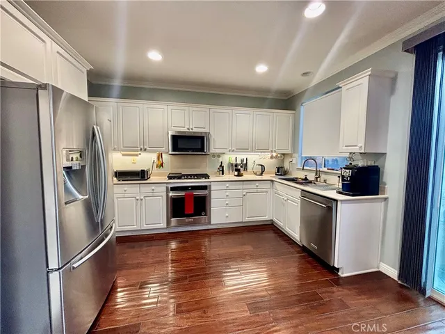 a kitchen with a refrigerator cabinets and wooden floor