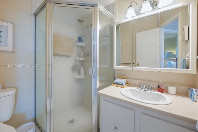 a bathroom with a sink and mirror with toilet