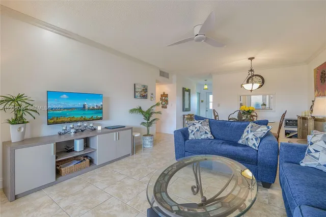 a living room with furniture a window and a flat screen tv