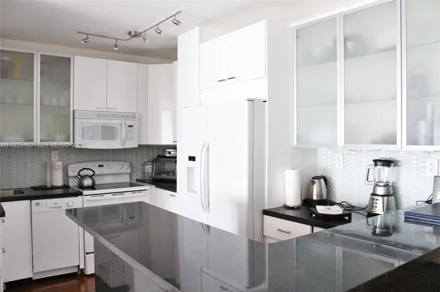 a kitchen with cabinets appliances a sink and a counter top space