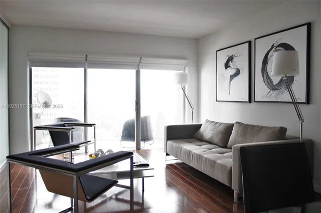 a living room with furniture a large window and a flat screen tv