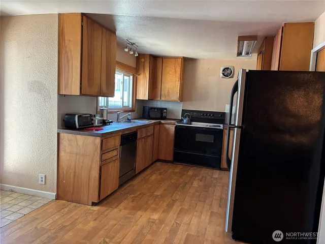 a kitchen with a sink a refrigerator and cabinets