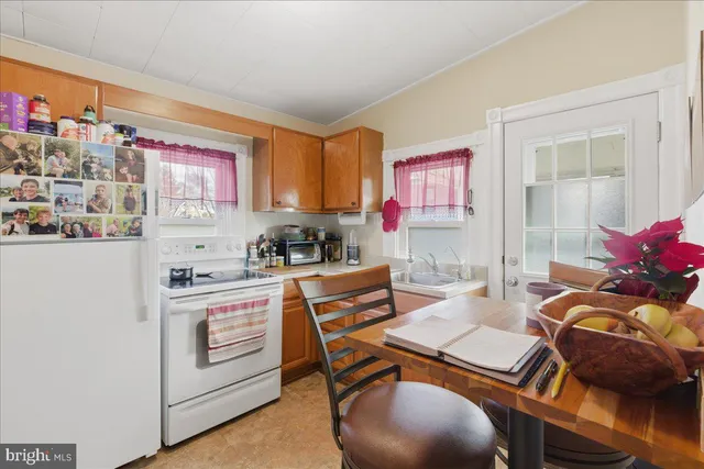 a kitchen with stainless steel appliances granite countertop a stove a refrigerator and a dining table with wooden floor