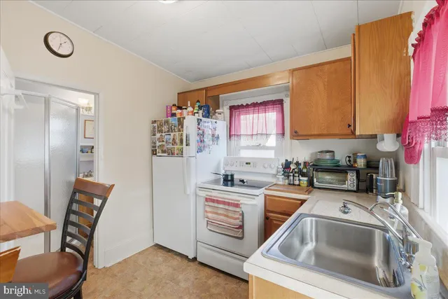 a view of a kitchen with fridge and workspace