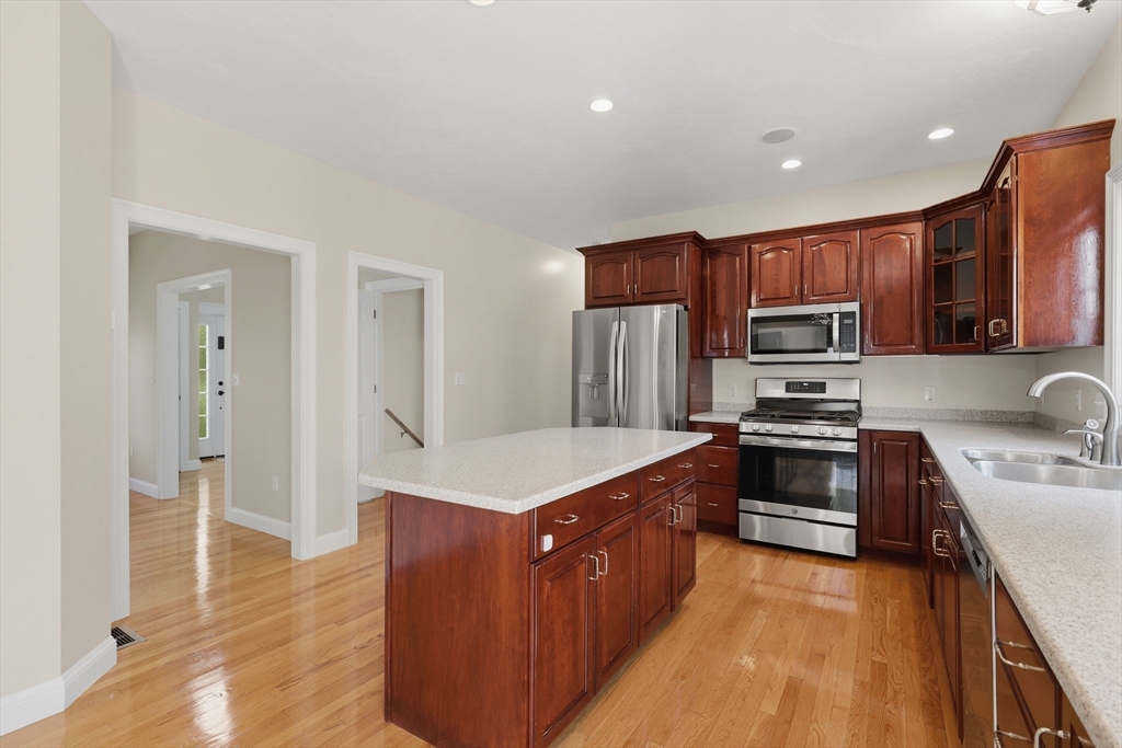 61 Indian Head Road Framingham, MA 01701 - Photo 11 of 42 a kitchen with stainless steel appliances a sink stove refrigerator and cabinets
