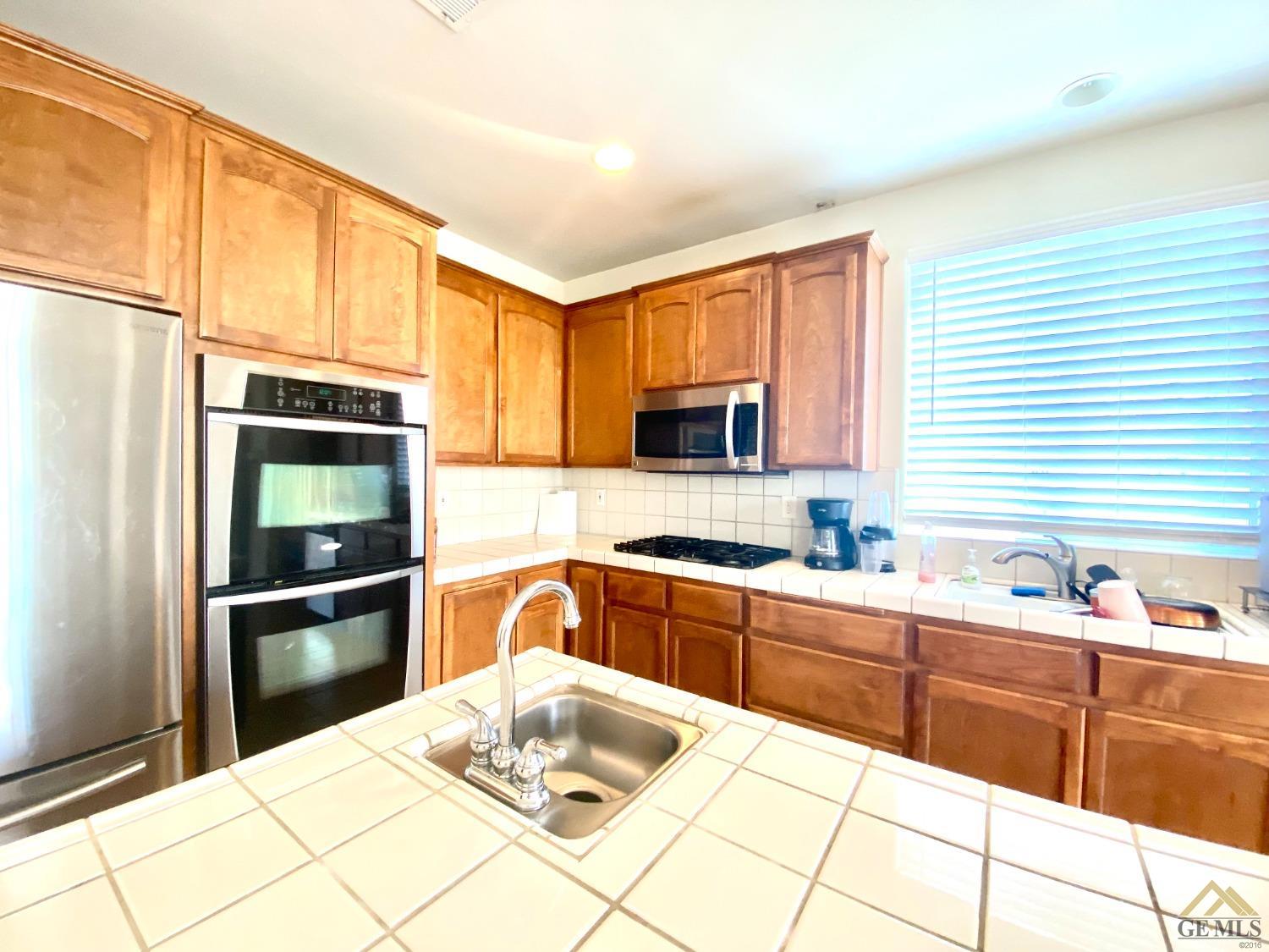Undisclosed Address Bakersfield, CA 93312 - Photo 11 of 38 a kitchen with stainless steel appliances granite countertop a refrigerator and sink