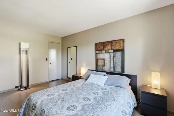 a bedroom with a bed and a painting on the wall