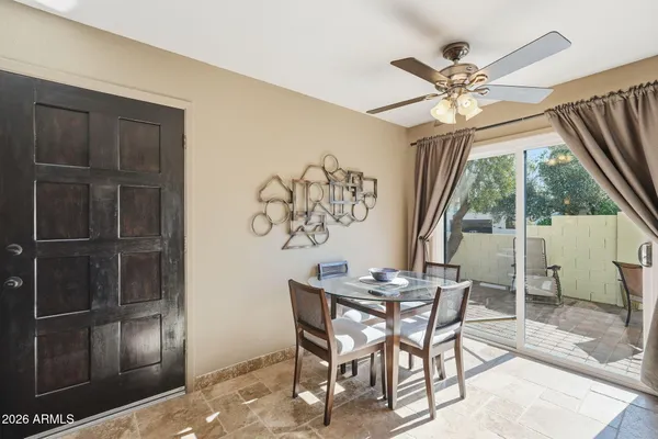 a dining room with a glass top table and chairs