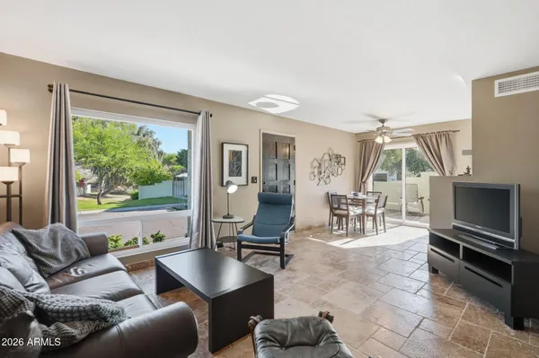 a living room with furniture a large window and a flat screen tv