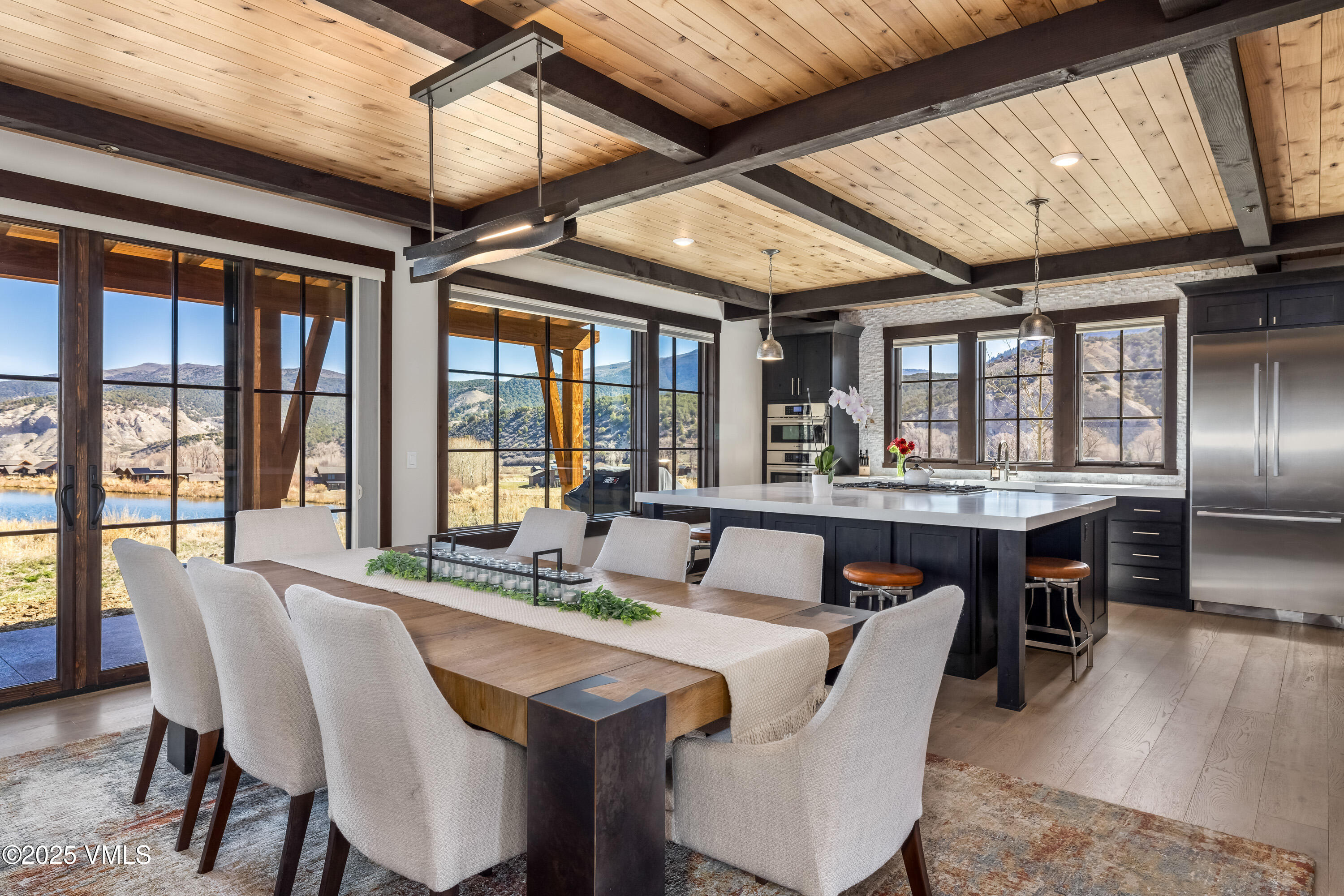 140 Hunters View Lane Eagle, CO 81631 - Photo 11 of 38 a dining room with wooden floor a chandelier a glass table and chairs