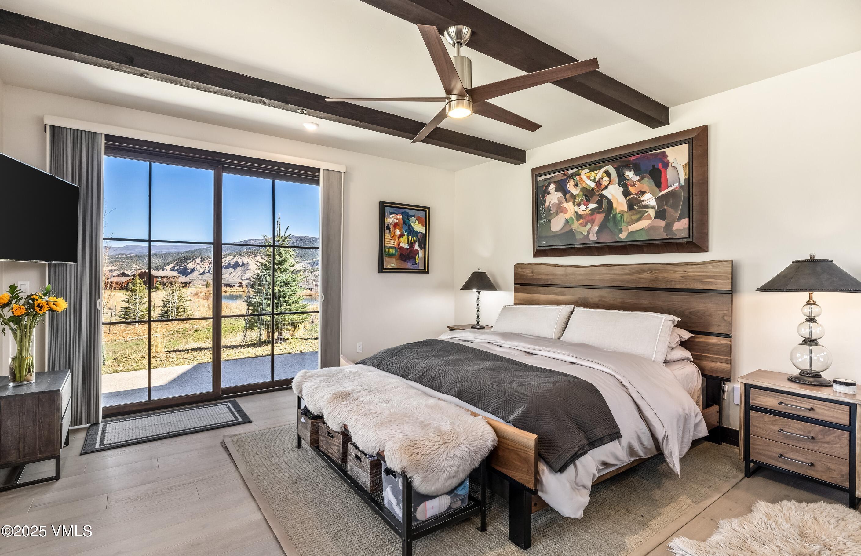140 Hunters View Lane Eagle, CO 81631 - Photo 13 of 38 a bedroom with a balcony a bed and a flat screen tv