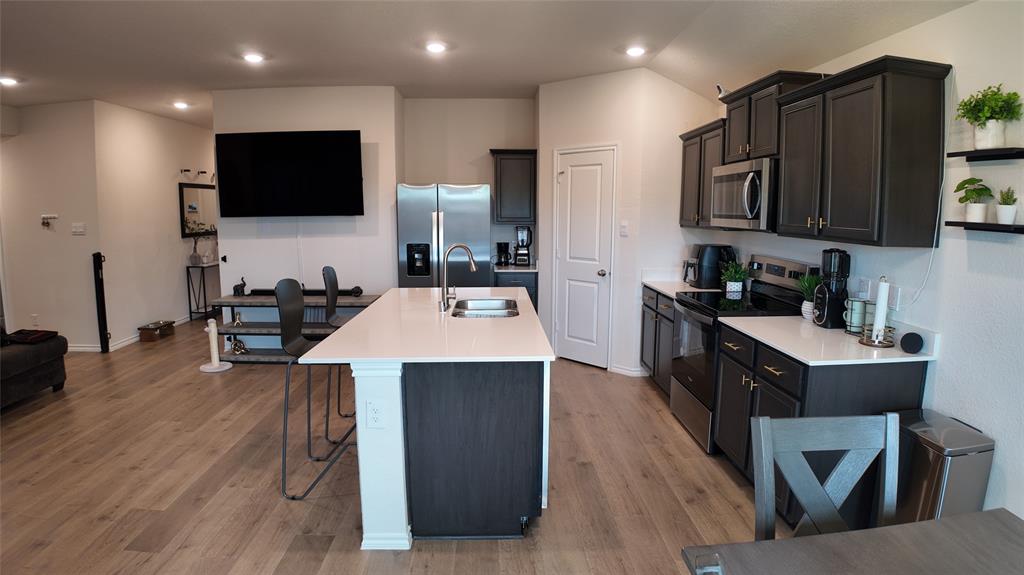 1215 Rustic Vw Lane Denton, TX 76207 - Photo 11 of 25 a kitchen with a sink stainless steel appliances and wooden floor