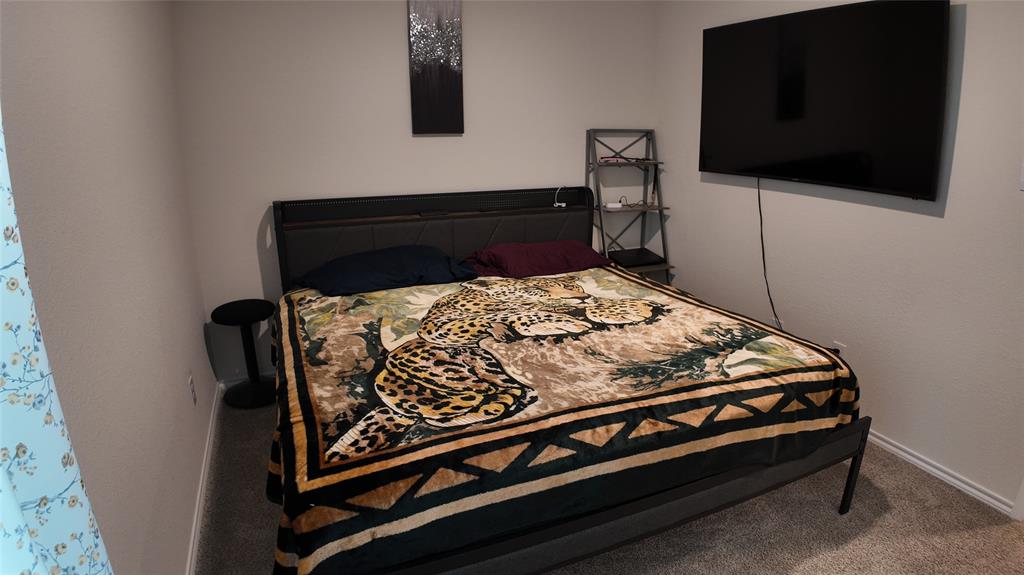 1215 Rustic Vw Lane Denton, TX 76207 - Photo 17 of 25 a bed sitting in a bedroom next to a flat screen tv