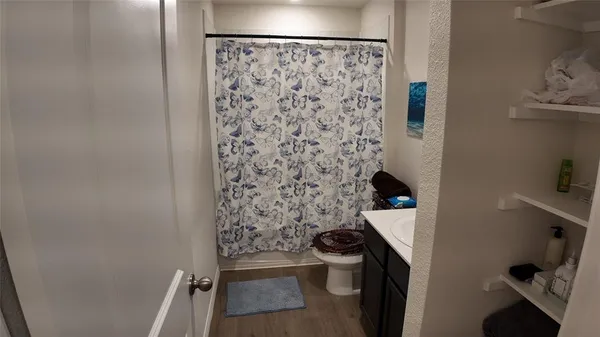 a bathroom with a toilet and a shower curtain