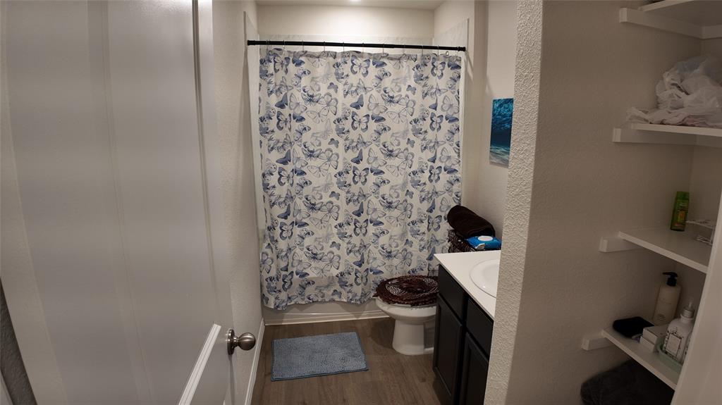 1215 Rustic Vw Lane Denton, TX 76207 - Photo 18 of 25 a bathroom with a toilet and a shower curtain
