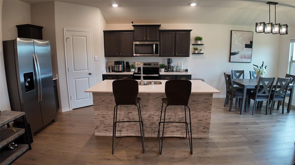 1215 Rustic Vw Lane Denton, TX 76207 - Photo 9 of 25 a kitchen with stainless steel appliances kitchen island granite countertop a refrigerator and microwave