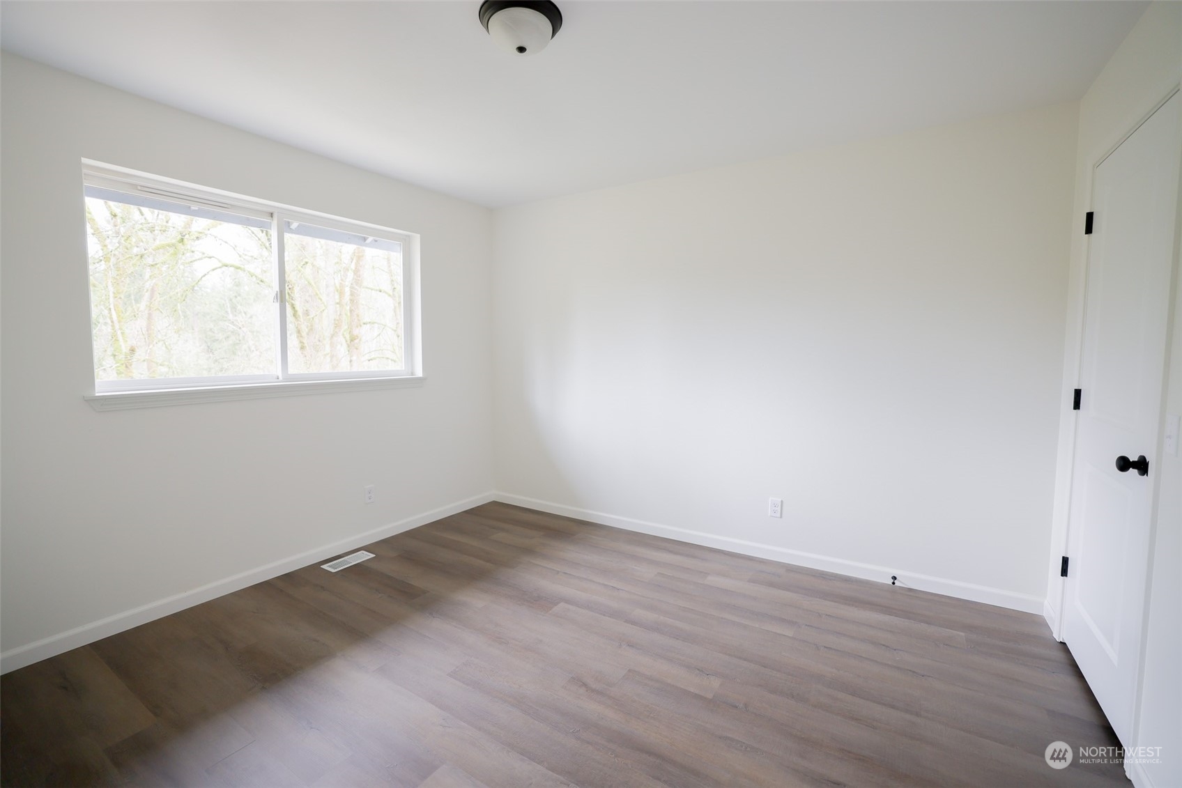 24833 Florence Acres Road Monroe, WA 98272 - Photo 12 of 21 an empty room with wooden floor and windows
