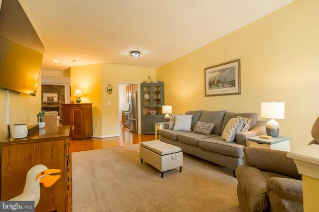 a living room with furniture a flat screen tv and kitchen view
