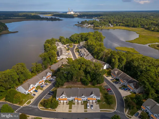 an aerial view of a residential houses with outdoor space and lake view