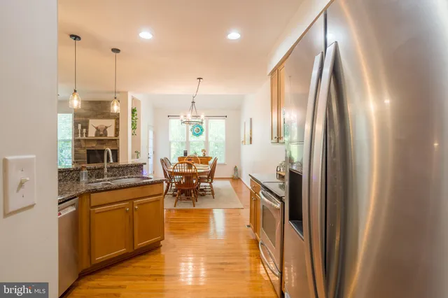 a kitchen with stainless steel appliances granite countertop a stove a sink and a refrigerator