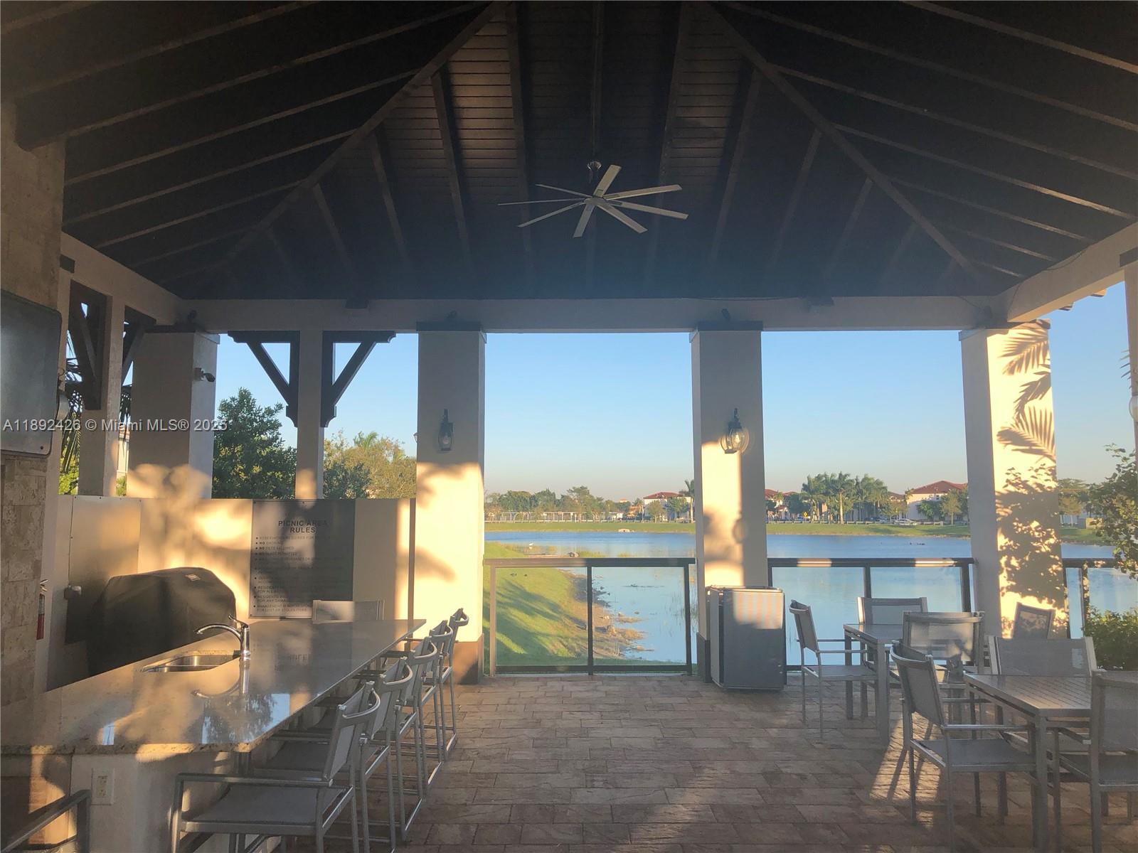 17105 Southwest 96th Street, Unit STUDIO Miami, FL 33196 - Photo 20 of 30 a view of a dining room with furniture large windows and wooden floor