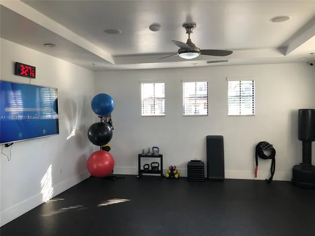 a room with gym equipment and large windows