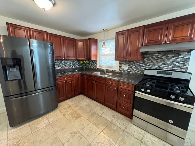a kitchen with stainless steel appliances granite countertop a stove a refrigerator and a stove