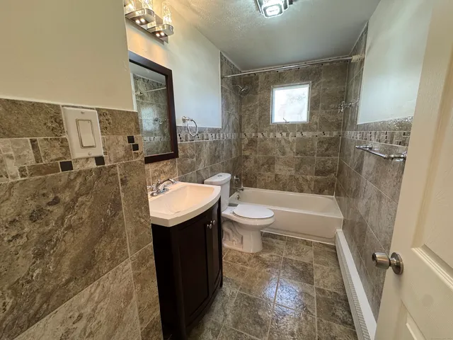 a bathroom with a sink a toilet a mirror and bathtub