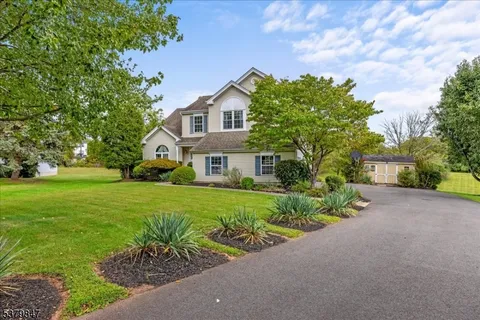 a front view of a house with a yard and potted plants