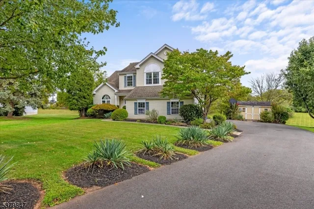 a front view of a house with a yard and potted plants