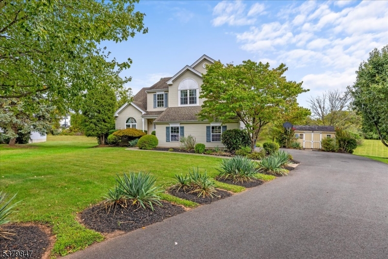 a front view of a house with a yard and potted plants