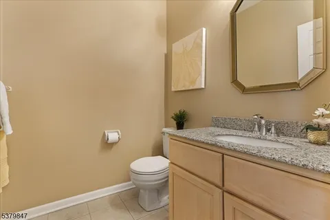 a bathroom with a granite countertop toilet sink and mirror