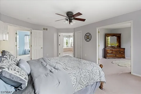 a spacious bedroom with a bed and ceiling fan
