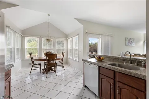a kitchen with stainless steel appliances granite countertop sink table and chairs