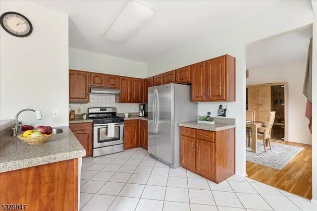 a kitchen with granite countertop a sink cabinets and stainless steel appliances