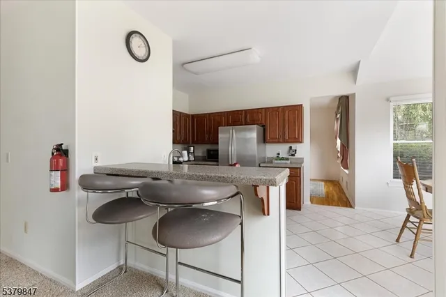 a kitchen with stainless steel appliances granite countertop a sink and a refrigerator