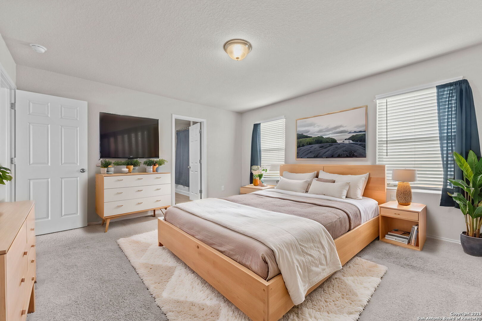 7115 Mesa Cliffs Converse, TX 78109 - Photo 20 of 30 a bedroom with a large bed and a flat screen tv