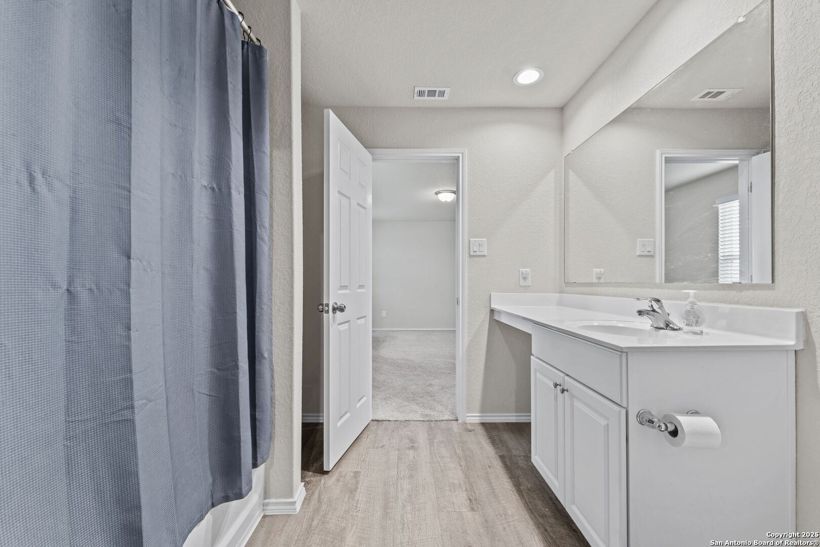 7115 Mesa Cliffs Converse, TX 78109 - Photo 22 of 30 a bathroom with a sink a mirror a vanity and a shower