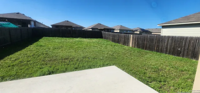 a view of a yard with wooden fence